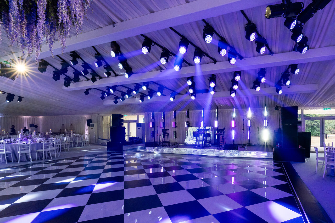 Wedding marquee lighting production in the UK with moving head lights, LED pixel bars, a black and white dance floor and a live music stage